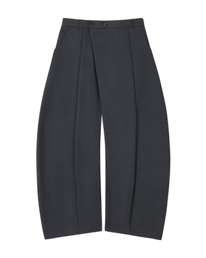 The CHARCOAL PLEATED HANBOK SLACKS by Sundae School are wide-leg, dark gray wool pants featuring deep pleats, a high waist with belt loops and two buttons, and side pockets. Reminiscent of the balloon silhouette found in hanbok pants, they are shown laid flat against a white background.