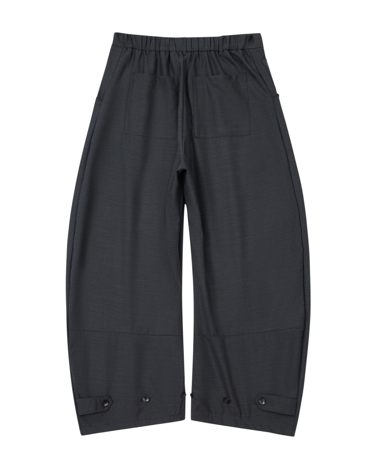 CHARCOAL PLEATED HANBOK SLACKS by Sundae School, featuring a wide-leg silhouette in black with pleated detailing, an elastic waistband, two back pockets, and adjustable button tabs at the ankles, laid flat on a white background.