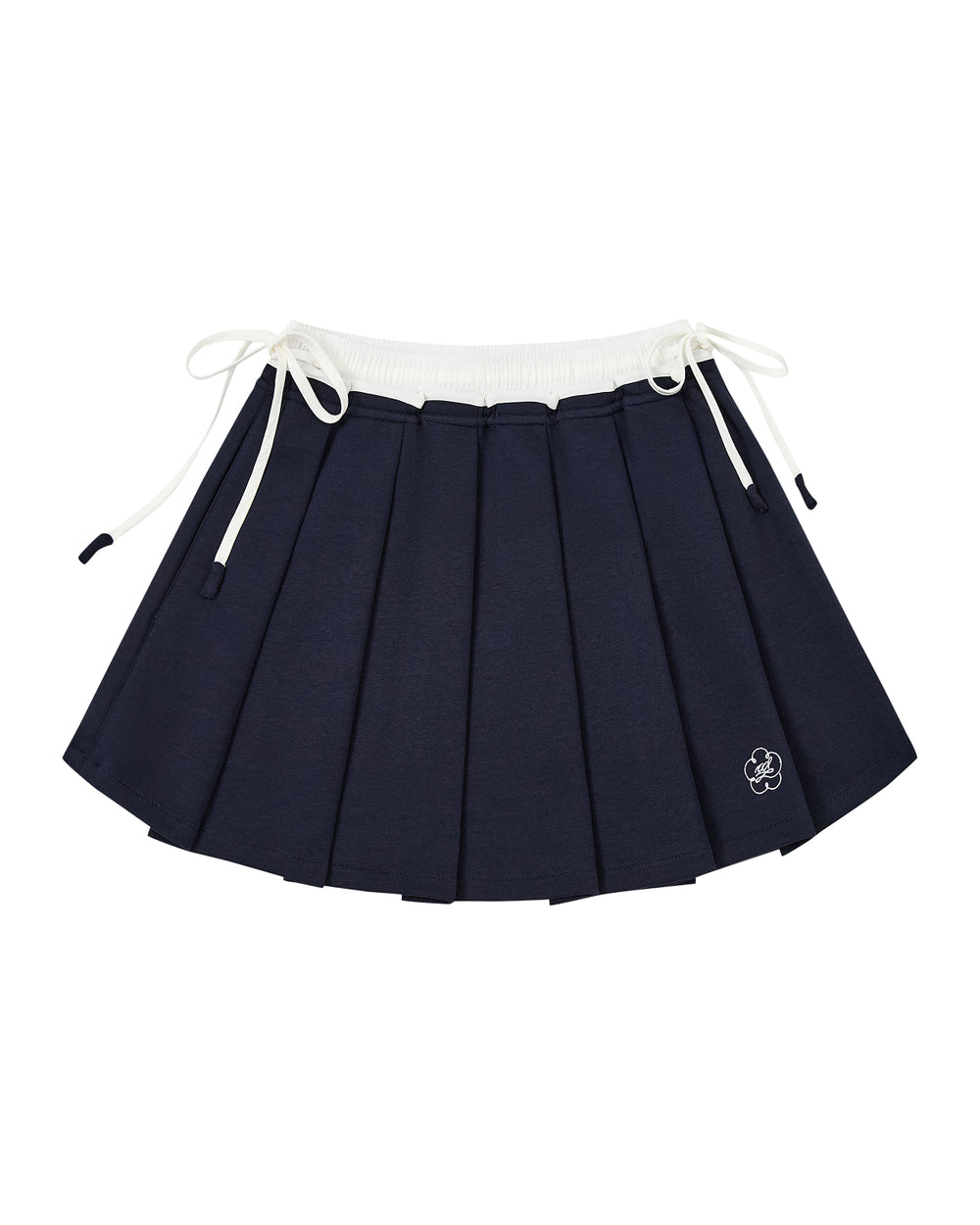 The NAVY PLEATED JERSEY MINI SKIRT by Sundae School features navy blue knife pleats, a white elastic waistband, white drawstrings on each side, and a small embroidered flower near the hem.