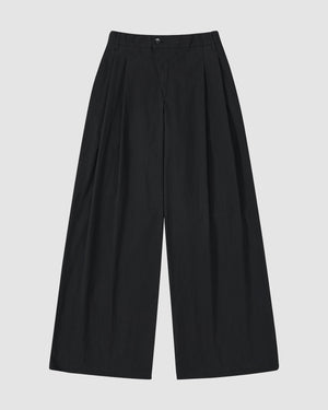 Sundae School's BLACK PLEATED UNIFORM SLACKS are unisex, high-waisted, with a wide-leg fit, front pleats, and button-zipper closure, inspired by Korean school uniforms and shown on a plain white background.