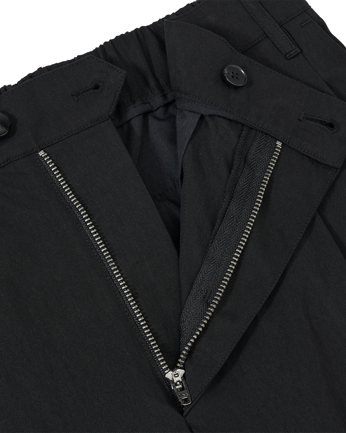 Close-up of Sundae School BLACK PLEATED UNIFORM SLACKS, showing a partially unzipped metal zipper, button closure at the waistband, and visible inner lining with detailed stitching.