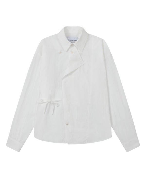 The WHITE POPLIN TIE GORUM SHIRT by Sundae School is a unisex, tailored-fit white long-sleeve shirt crafted from cotton nylon poplin. It features an asymmetrical front, classic collar, and distinctive side tie detail, with a double-layered front panel adding dimension. Shown on a plain background.