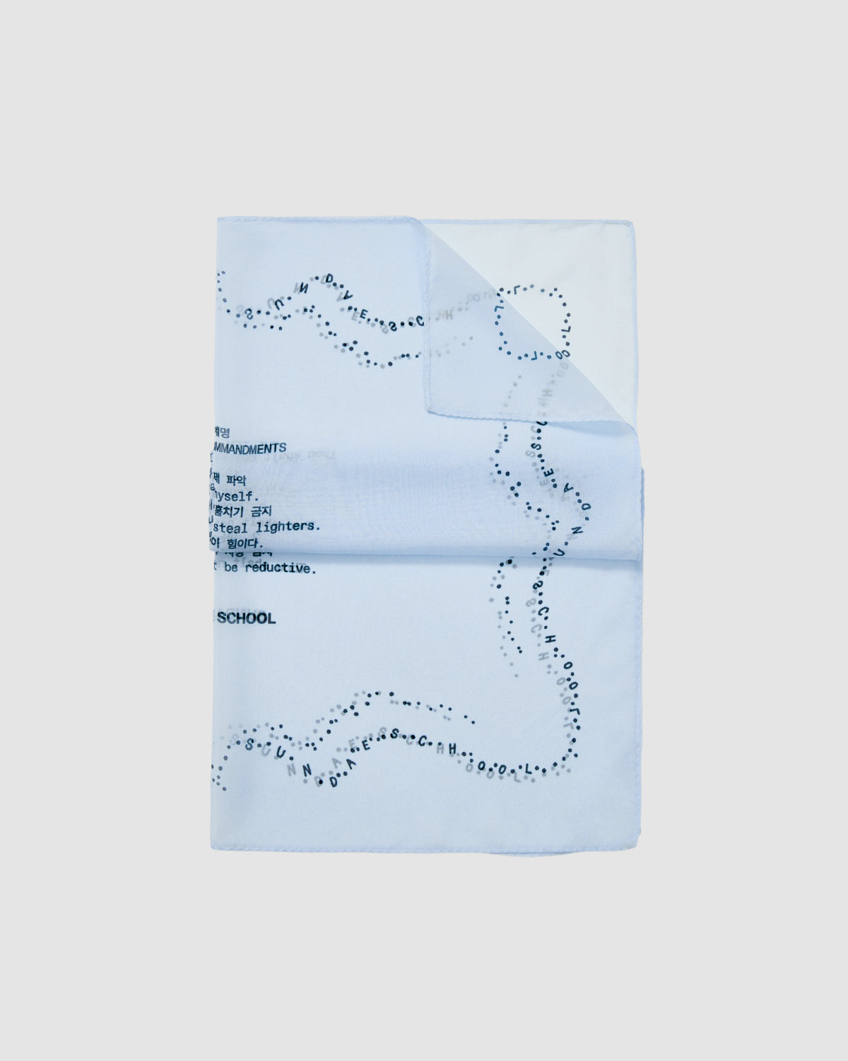 The SKY BLUE 10 COMMANDMENTS ORGANZA BANDANA by Sundae School is a light blue silk organza piece with black scattered letters forming a wavy border and partial Sundae School Ten Commandments text in the top left.