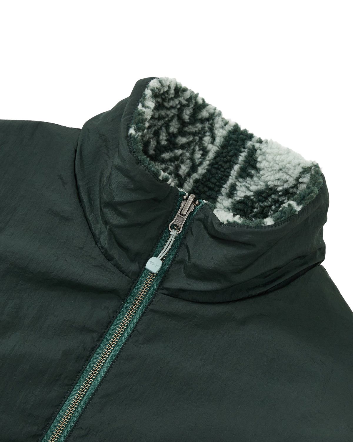 Close-up of the Sundae School TEAL REVERSIBLE GOSTOP FLEECE jacket, showcasing a stand collar zip up and a soft, light and dark gray patterned reversible sherpa fleece lining on the collar.