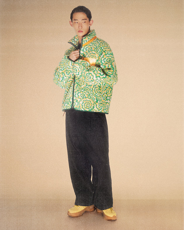 a male model wearing Sundae School Broccoli Fleece against a brown background.