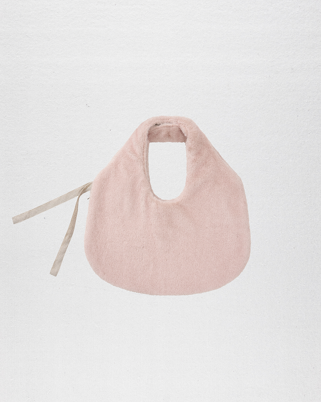 a model wearing Sundae School Silver Pink Baeja Vest / Tote in the vest form against a brown background