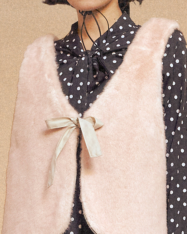 a model wearing Sundae School Silver Pink Baeja Vest / Tote in the vest form against a brown background