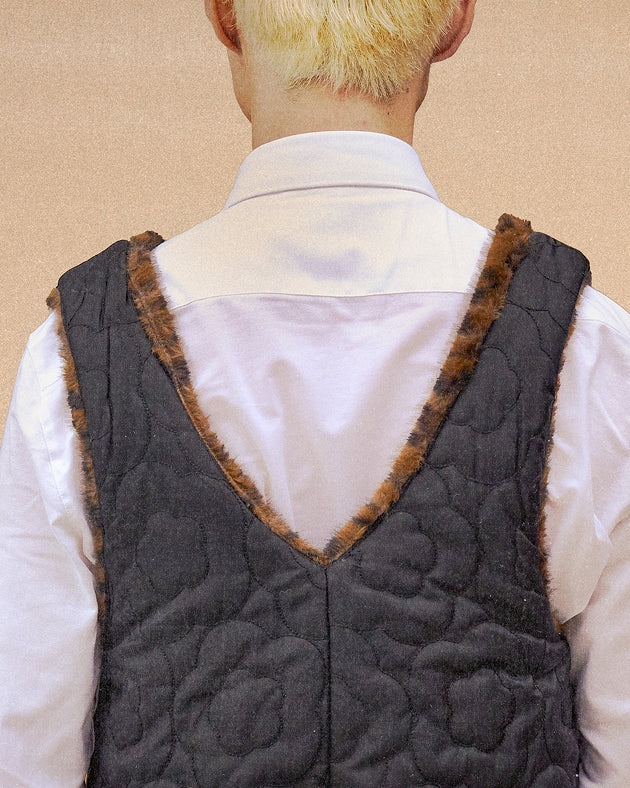A model wearing Sundae School Black Leopard Baeja Vest / Tote in the vest form against a brown background.