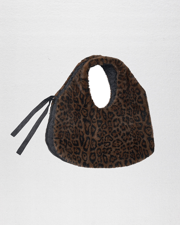 A model wearing Sundae School Black Leopard Baeja Vest / Tote in the vest form against a brown background.