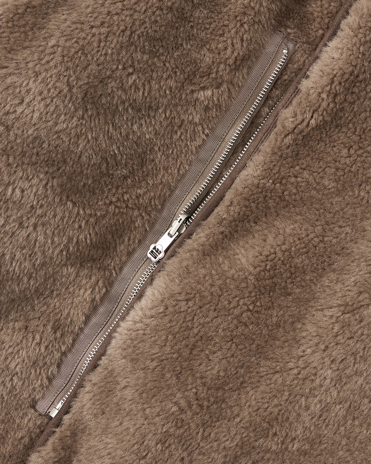 Close-up of a zipper on the brown teddy fleece side