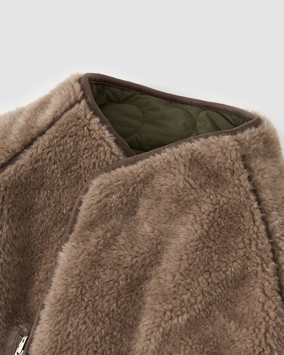 Close-up detail of the Reversible Flower Quilted Jeogori Fleece collar showing the brown teddy fleece side