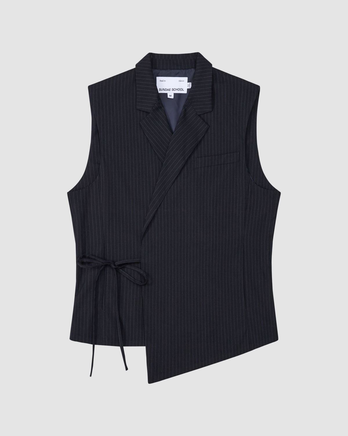 The SABRINA VEST by Sundae School is a sleeveless black pinstripe wool vest with an asymmetrical front, notch collar, single chest pocket, and side Korean goreum tie. The interior label reads SÉFR SHADE SCHOOL and it's shown laid flat on a light gray background.