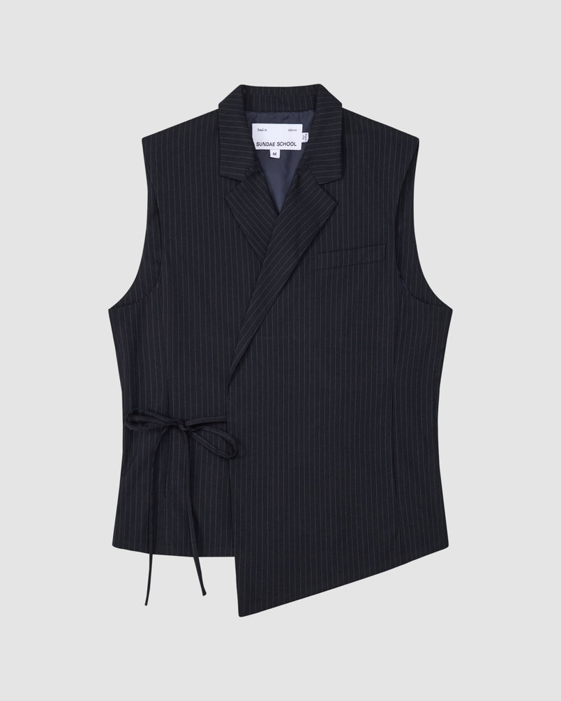 The SABRINA VEST by Sundae School is a sleeveless black pinstripe wool vest with an asymmetrical front, notch collar, single chest pocket, and side Korean goreum tie. The interior label reads SÉFR SHADE SCHOOL and it's shown laid flat on a light gray background.