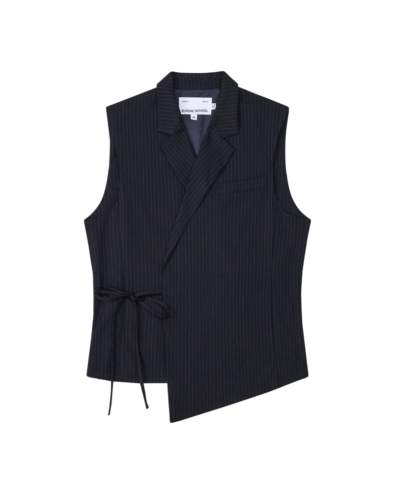 The SABRINA VEST by Sundae School is a sleeveless black pinstripe rayon blend vest featuring an asymmetric hem, side Korean goreum tie, lapel collar, and a single chest pocket, shown on a white background.