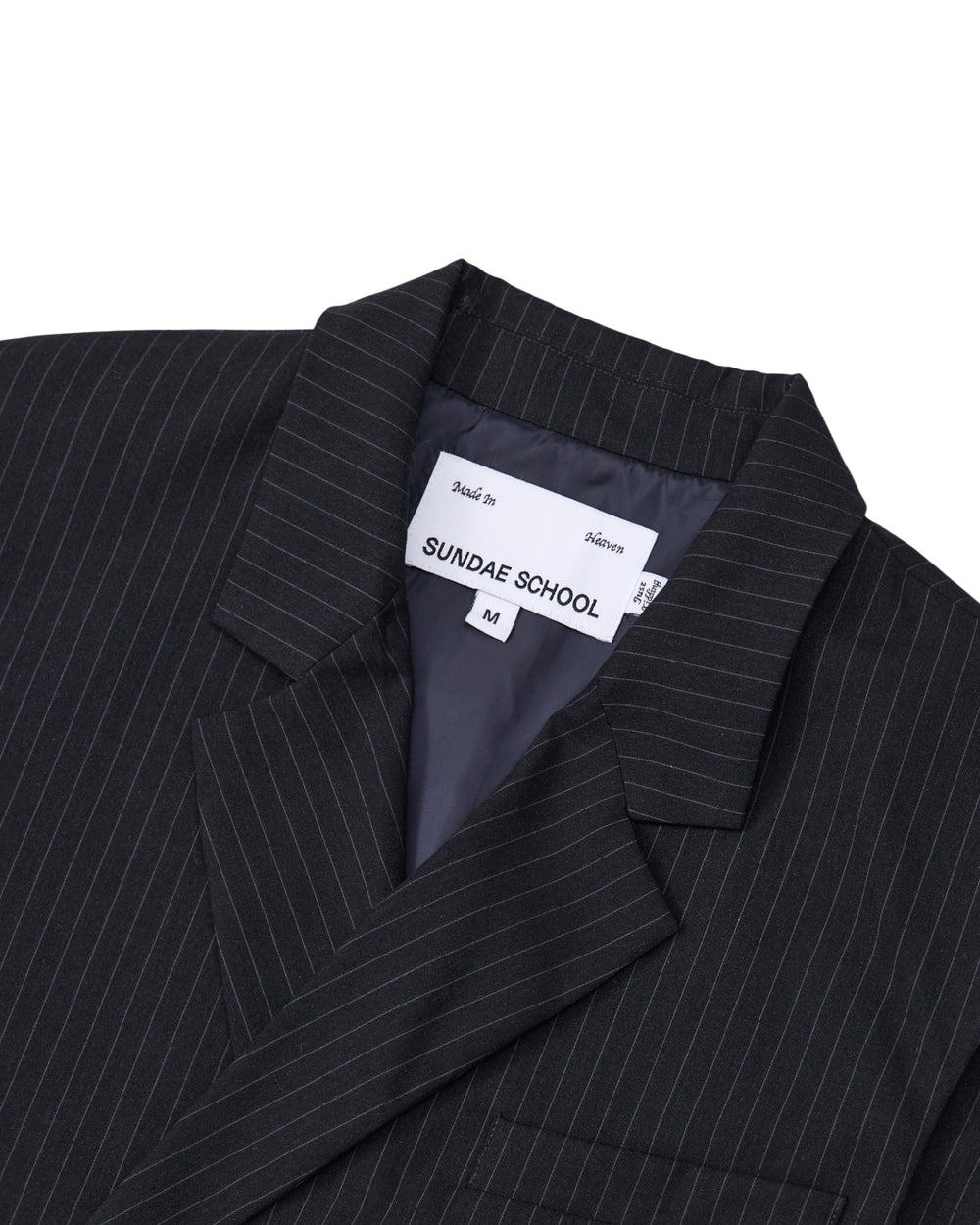 Close-up of the SABRINA VEST in a black pinstripe rayon blend, featuring a visible Sundae School label and size M inside the collar. The inner lining is dark and smooth, and the vest showcases classic lapels.