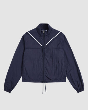 The Sundae School NAVY SAILOR WINDBREAKER is a navy cropped jacket with a high collar, long sleeves, elastic cuffs, and V-shaped white piping on the chest, shown laid flat on a light gray background.