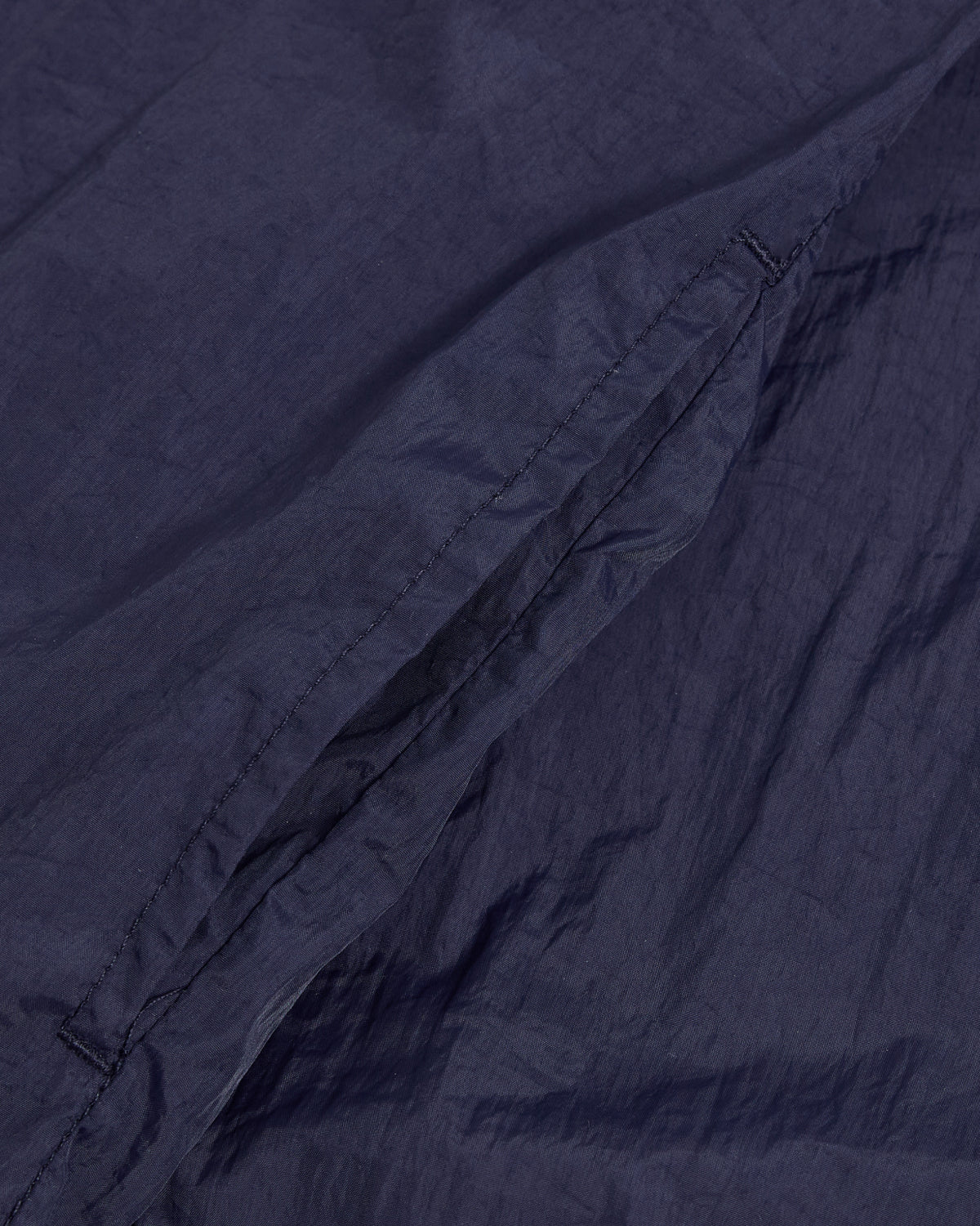 Close-up of the NAVY SAILOR WINDBREAKER by Sundae School, highlighting its dark blue fabric, detailed stitching, angled pocket, and UV protection features.