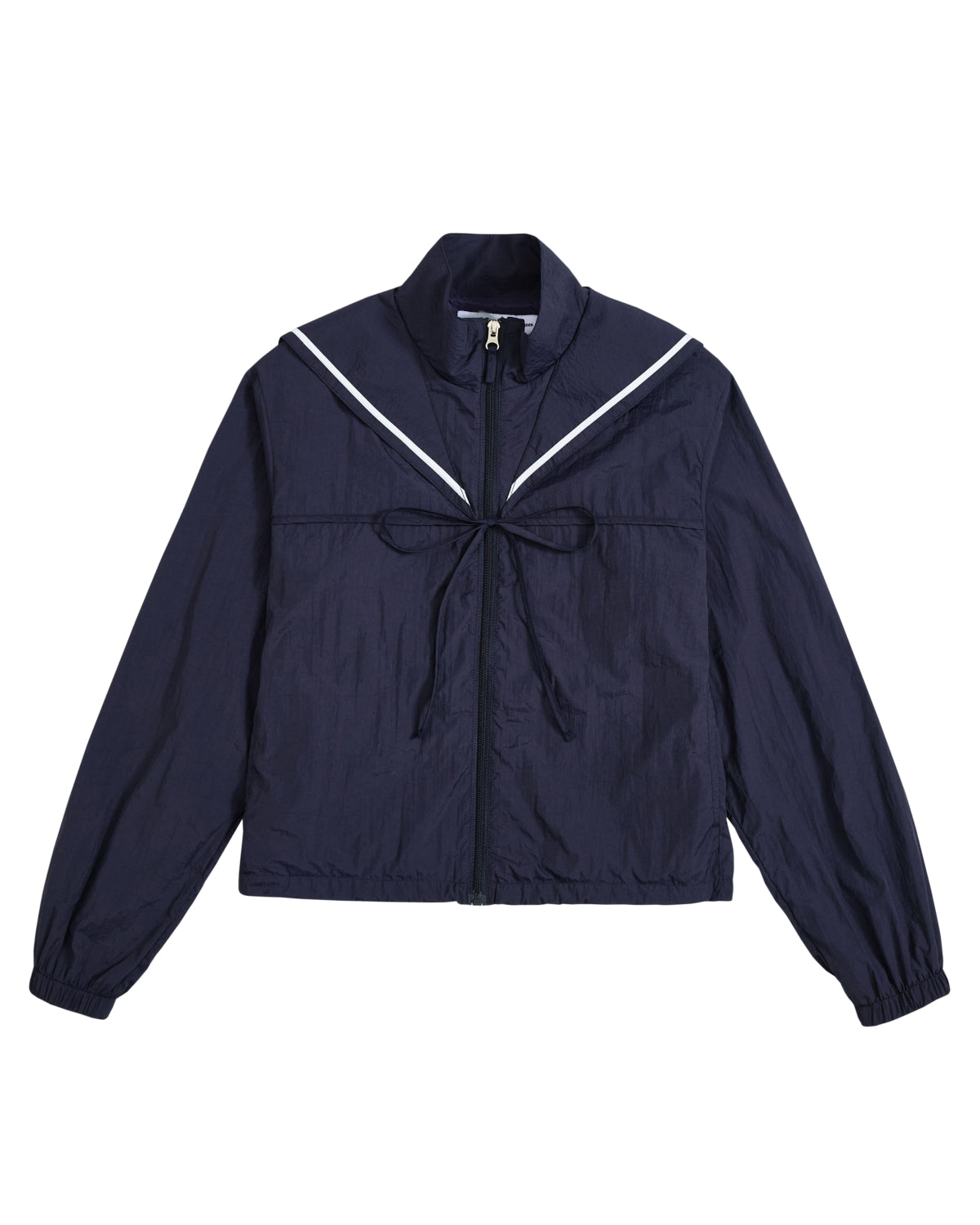Introducing the NAVY SAILOR WINDBREAKER from Sundae School—a cropped zip-up jacket in navy blue, featuring a sailor-style collar with white trim and a front bow. The long sleeves have elastic cuffs, while the slightly crinkled texture adds modern flair. This playful windbreaker blends classic charm with contemporary style for a fresh look.