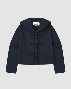 The NAVY SAILOR COLLAR UNIFORM JACKET by Sundae School features a dark navy hue, mochi quilted stitching, long sleeves, hood, front tie closures, two vertical pockets, and an inner collar label, shown on a light gray background.