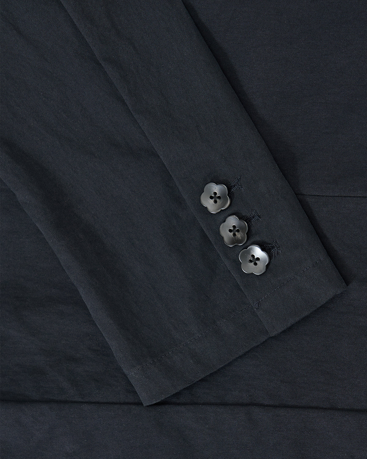 Close-up of the NAVY SAILOR COLLAR UNIFORM JACKET by Sundae School, showing three neatly sewn four-hole black buttons on the sleeve cuff, highlighting smooth, finely tailored fabric and precise sailor collar detailing.