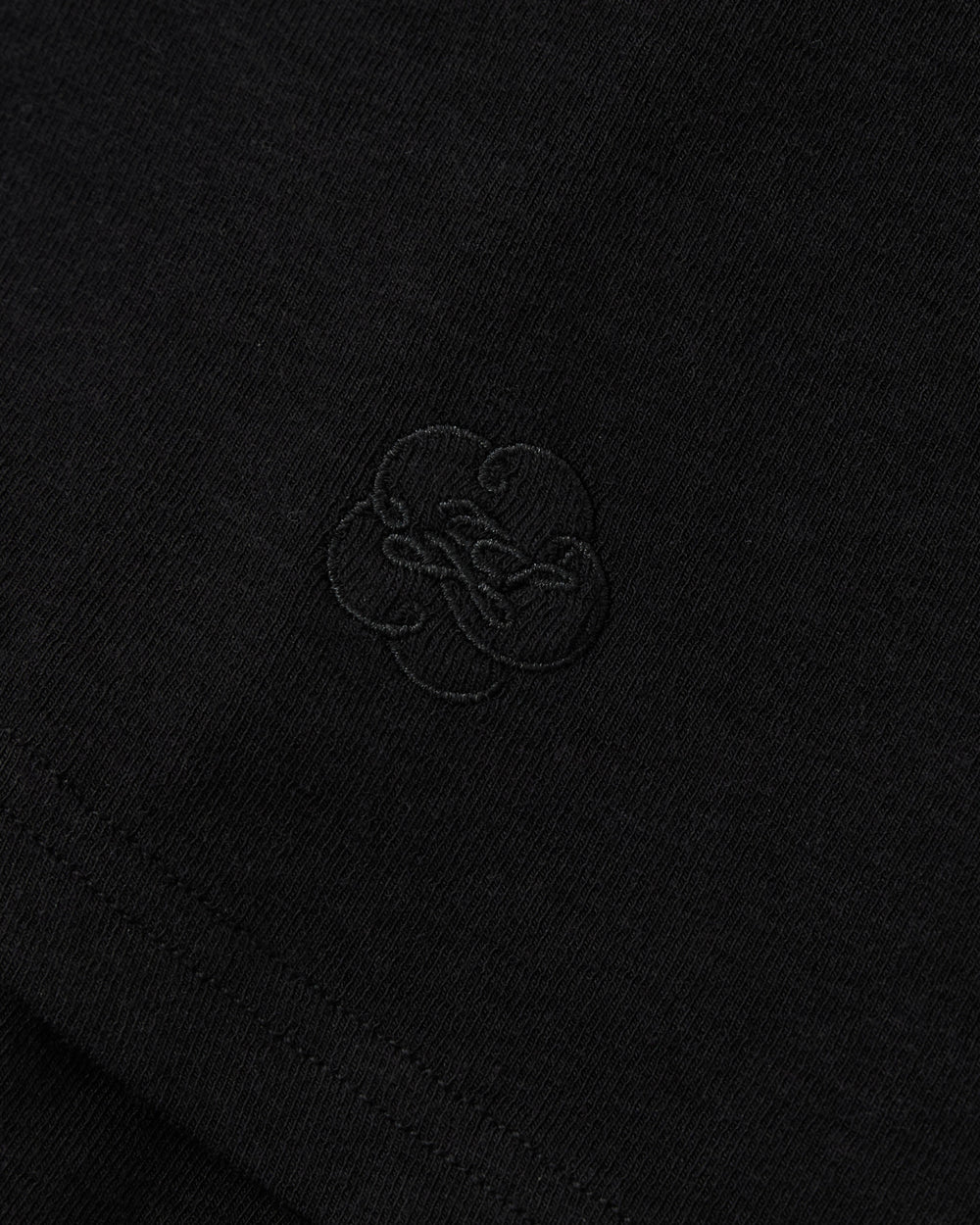 BLACK SEONGSU APRON PANTS in black fabric with a wide-leg silhouette and an embroidered tonal floral design in the center.