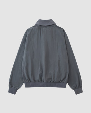 The Sundae School CHARCOAL SHAWL COLLAR ANORAK is a plain, long-sleeved gray jacket with a shawl collar, ribbed cuffs, and waistband, shown from the back and inspired by monk-core style.