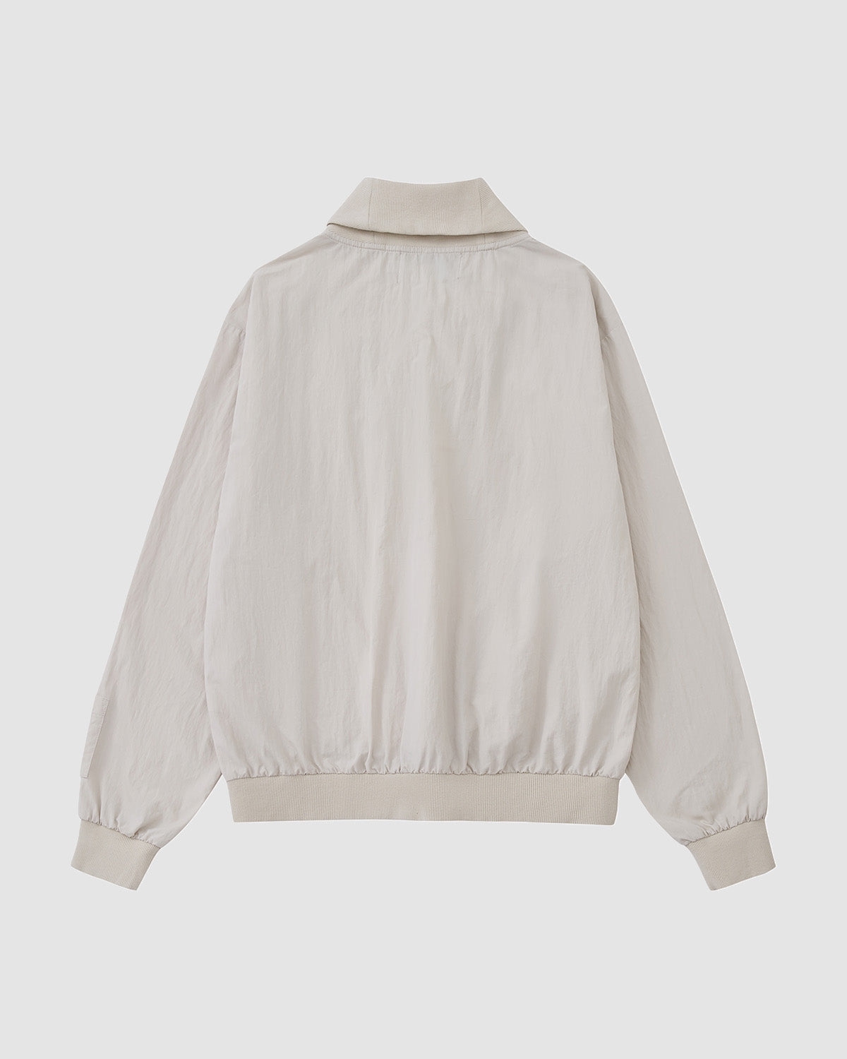 Back view of Sundae School's IVORY SHAWL COLLAR ANORAK in light beige, featuring long sleeves, a shawl collar, ribbed cuffs and hem, made from a cotton-nylon shell, shown against a plain white background.
