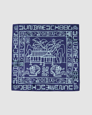 The NAVY SILK BANDANA by Sundae School features light blue line illustrations of palm trees, benches, and tigers with stylized Hangeul script and “SUNDAY SCHOOL” in English and Korean around the border.