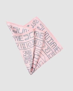 The Sundae School PINK SILK BANDANA is a refined Korean heritage accessory, featuring abstract grey Hunminjeongeum-inspired motifs on light pink silk, elegantly folded against a plain light gray background.