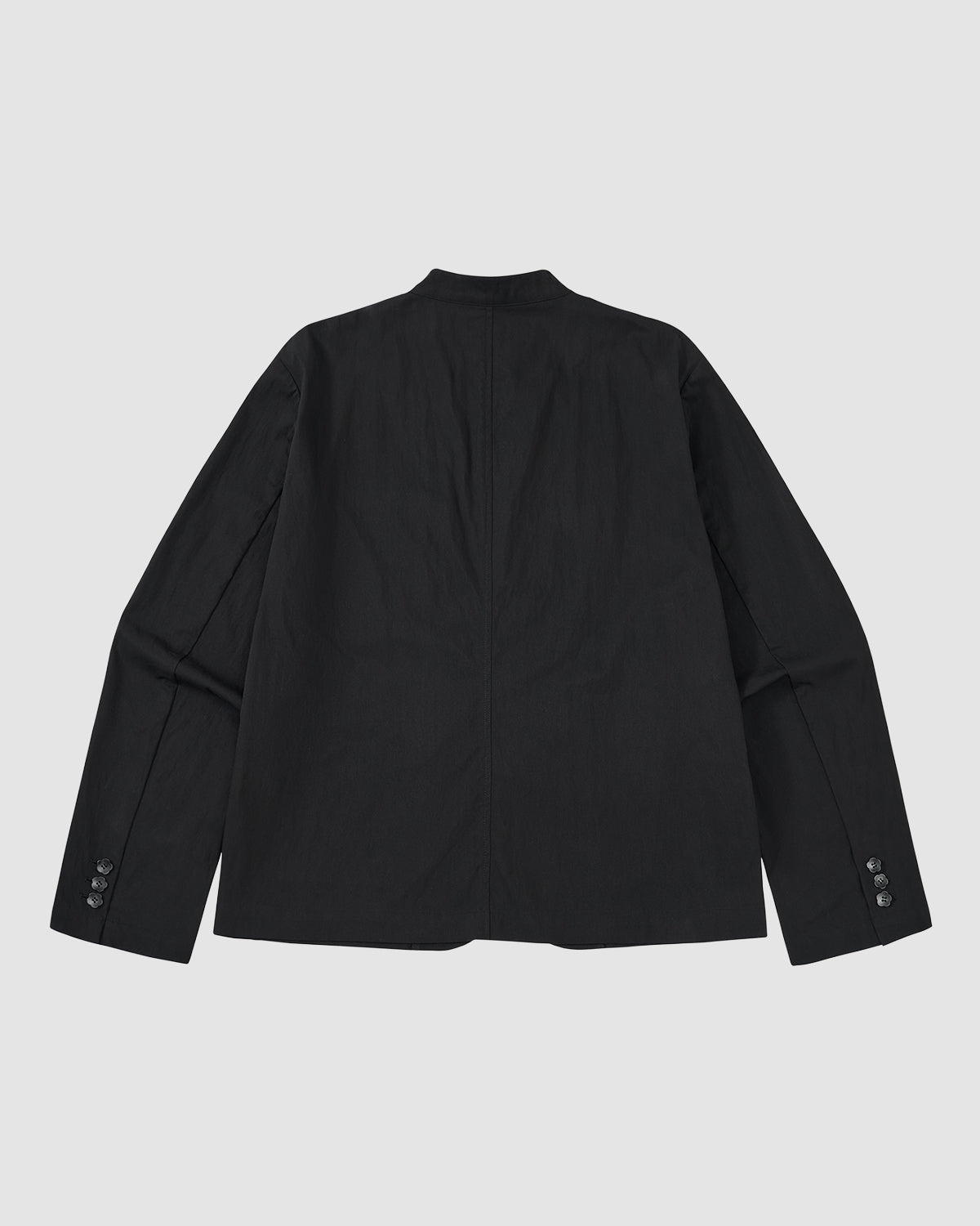 The BLACK STAND COLLAR UNIFORM JACKET by Sundae School is shown flat, back facing up, with long sleeves and buttoned cuffs on a light gray background. Crafted from a cotton nylon blend, it combines durability with style.