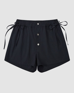 The Sundae School NAVY STRIPE BOXER SHORTS feature a pinstripe design, elastic waistband, side ties, and three front buttons. Crafted from a soft Tencel-rayon blend, the shorts are shown laid flat on a plain light gray background.