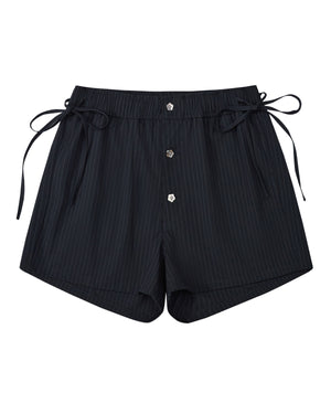 Sundae School’s STRIPED BOXER SHORTS feature classic black pinstripes, an elastic waistband, side ties, and three front buttons, all crafted from a lightweight rayon blend. Shown laid flat on a white background, these shorts are the ideal stylish and comfortable choice for working from home.