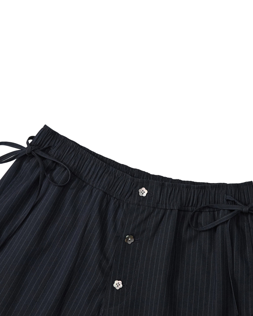 Close-up of the waistband of Sundae School’s STRIPED BOXER SHORTS, crafted from a lightweight rayon blend with dark pinstripes, featuring an elastic band, side drawstrings, and three visible buttons down the front—ideal for those wanting the comfort of work-from-home shorts with a polished look.