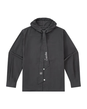 The CHARCOAL SUNBAE TIE SHIRT by Sundae School is a long-sleeve black button-up with a ruffled collar and an attached necktie adorned with white embroidery, featuring a simple, modern design.