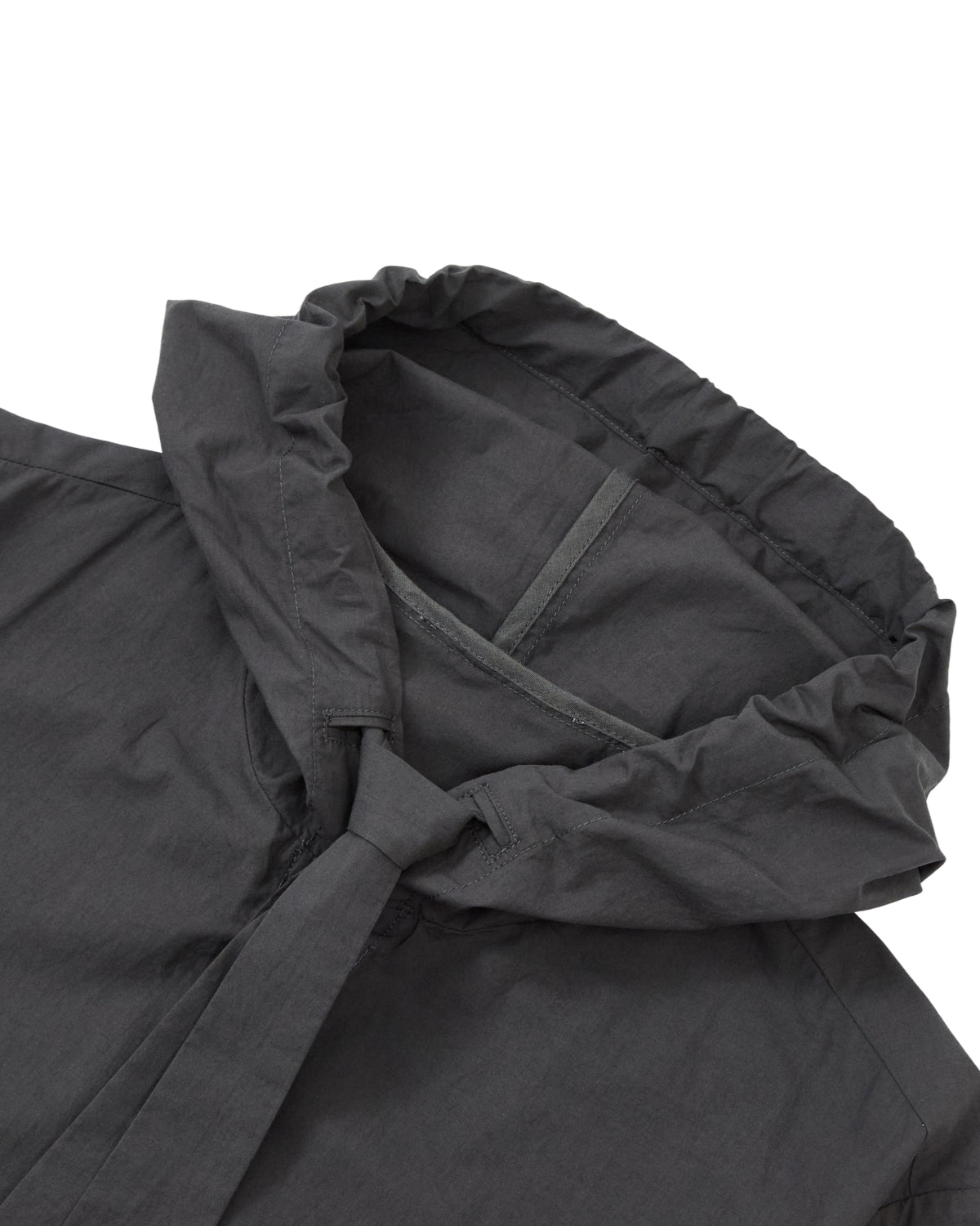 Close-up of the CHARCOAL SUNBAE TIE SHIRT by Sundae School, highlighting the edge of the charcoal hood and upper shoulder area. The lightweight fabric features subtle stitching details.