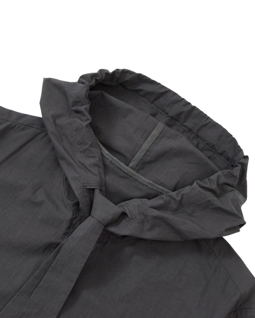 Close-up of the CHARCOAL SUNBAE TIE SHIRT by Sundae School, highlighting the edge of the charcoal hood and upper shoulder area. The lightweight fabric features subtle stitching details.