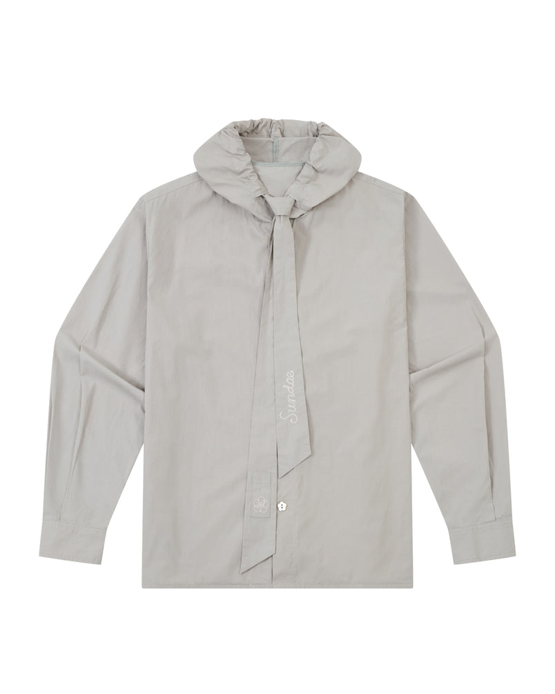 The GREY SUNBAE TIE SHIRT by Sundae School is a light gray, long-sleeve button-up featuring a wide, tied scarf collar with embroidered text. The shirt is displayed flat, showcasing its front details and button closures.