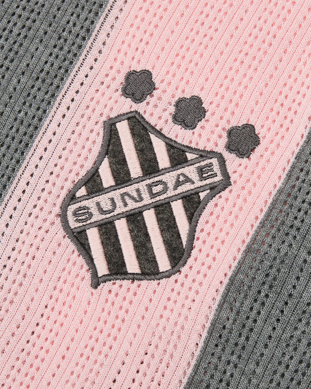 The PINK SUNDAE SOCCER JERSEY by Sundae School features a custom embroidered patch with a black and white striped shield, 
