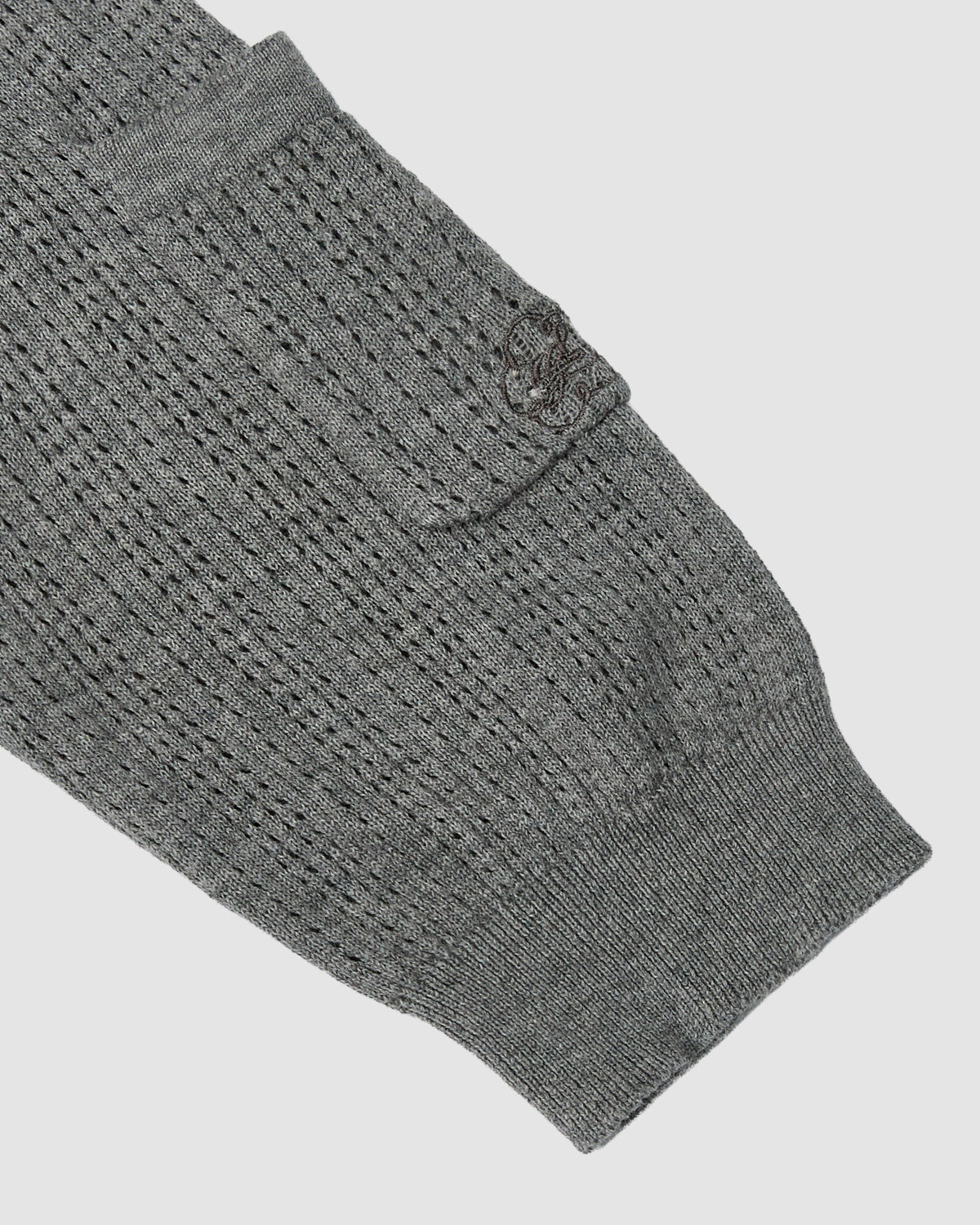 Close-up of the PINK SUNDAE SOCCER JERSEY sleeve by Sundae School, showcasing its textured knit pattern, small pocket with embroidered logo on the flap, and crafted from 100% cotton for a lightweight feel.