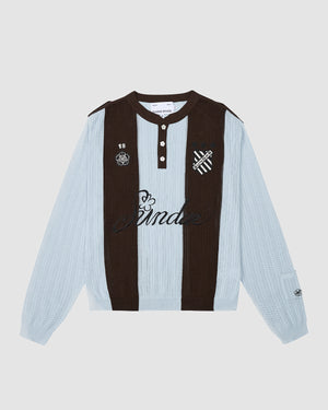 The SKY BLUE SUNDAE SOCCER JERSEY by Sundae School is a long-sleeve cotton knit polo with light blue and dark brown stripes, black collar and buttons, and embroidered B crest, 18, skull, and "Sunda" script on the chest.