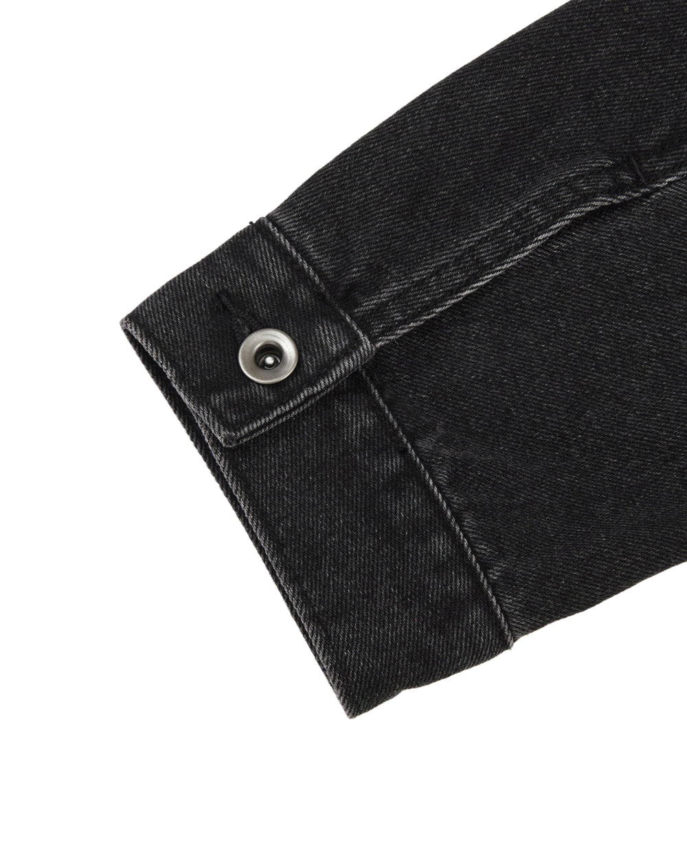 A close-up of the BLACK WIDOW TAEKWONDO DENIM JACKET sleeve by Sundae School, featuring visible stitching and a metal buttoned cuff, reminiscent of a collarless denim jacket often seen in the Korean Canadian tuxedo style, photographed against a white background.