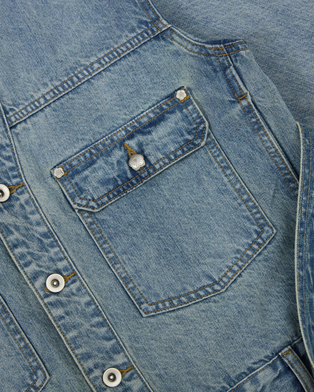 Close-up of the Sundae School MEDIUM BLUE TAEKWONDO DENIM JACKET, highlighting a chest pocket with a button flap, visible stitching, and metal buttons on the front placket—perfect for styling as part of a Korean Canadian tuxedo.