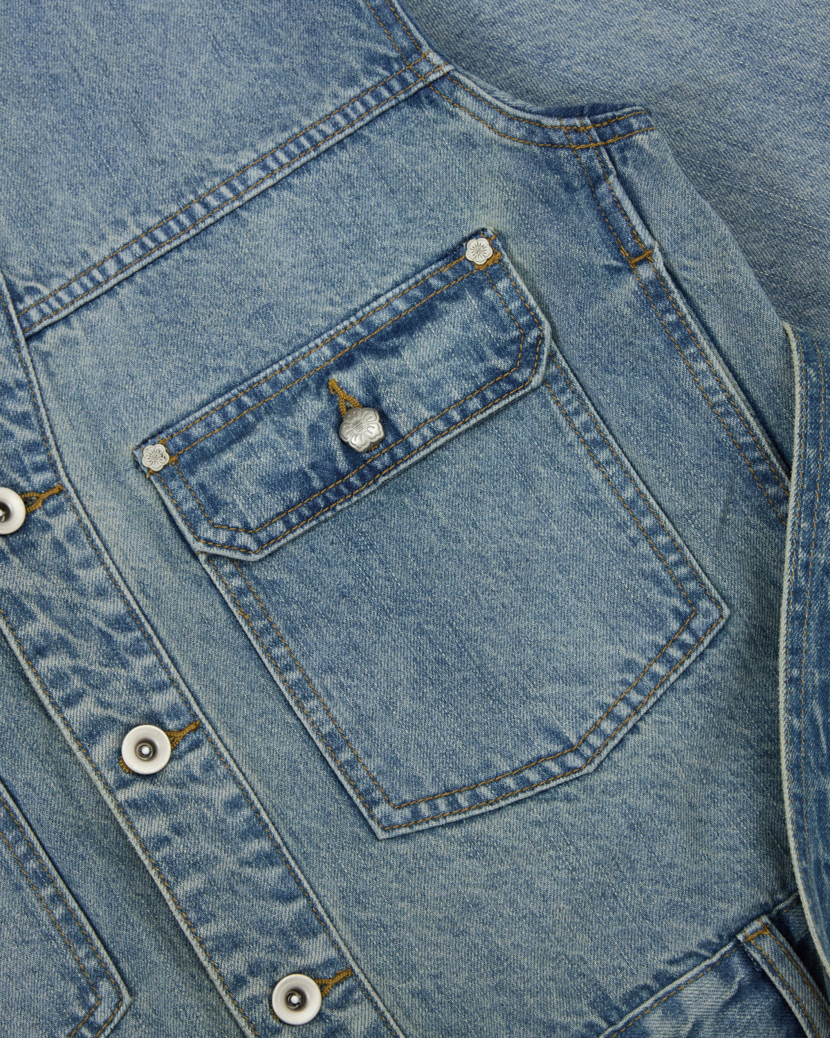 Close-up of the Sundae School MEDIUM BLUE TAEKWONDO DENIM JACKET, highlighting a chest pocket with a button flap, visible stitching, and metal buttons on the front placket—perfect for styling as part of a Korean Canadian tuxedo.