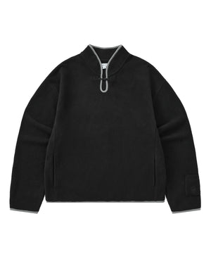 BLACK TEARDROP KNOT FLEECE by Sundae School: A black cozy fleece pullover featuring a high collar, gray trim accents, a distinctive front teardrop loop detail, side pockets, and a branded patch on the left sleeve. The garment is displayed laid flat against a white background.