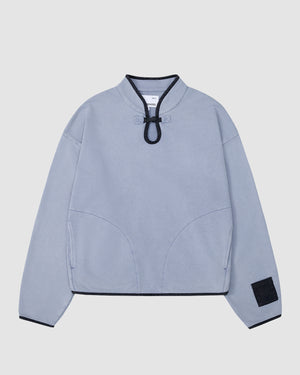 The SKY BLUE TEARDROP KNOT SWEATSHIRT by Sundae School is a long-sleeve design featuring teardrop knot details, black trim, curved seams, and a black patch on the left sleeve. Made from 100% cotton with a plain white background.