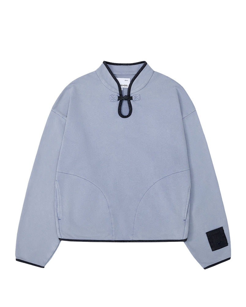 The SKY BLUE TEARDROP KNOT SWEATSHIRT by Sundae School is a light blue, long-sleeve piece crafted from 100% cotton for comfort. It features a black-trimmed collar and cuffs, a decorative black loop detail at the neckline, and a black patch on the left sleeve near the wrist. Subtle denim trim accents add an extra touch of style to this standout sweatshirt.