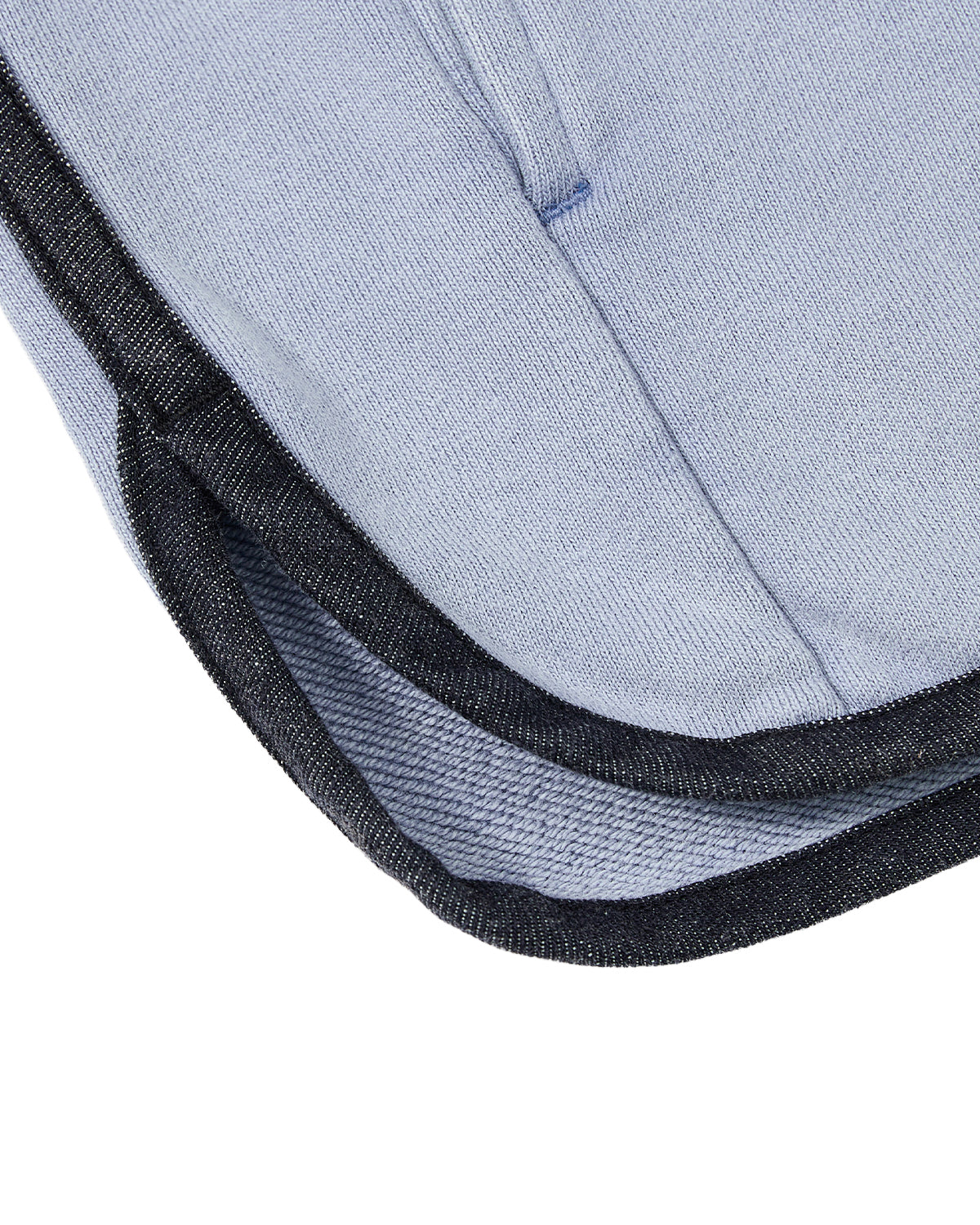 Close-up of the SKY BLUE TEARDROP KNOT SWEATSHIRT by Sundae School, featuring soft, slightly textured light blue 100% cotton fabric with black denim trim. Detailed stitching and a hemmed edge highlight the sweatshirt’s quality craftsmanship.