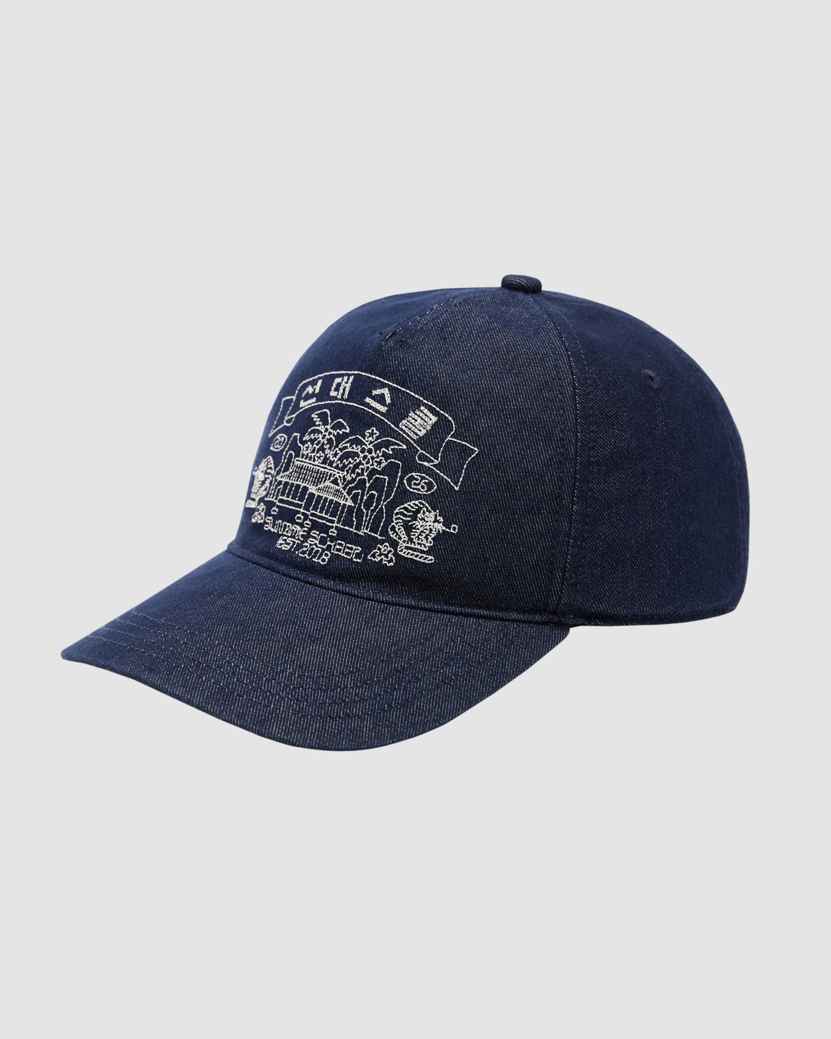 The INDIGO DENIM TIGER CAP by Sundae School is a navy blue, six-panel adjustable strapback with white embroidered graphics and text on the front. It features a curved brim and is shown on a plain light background.