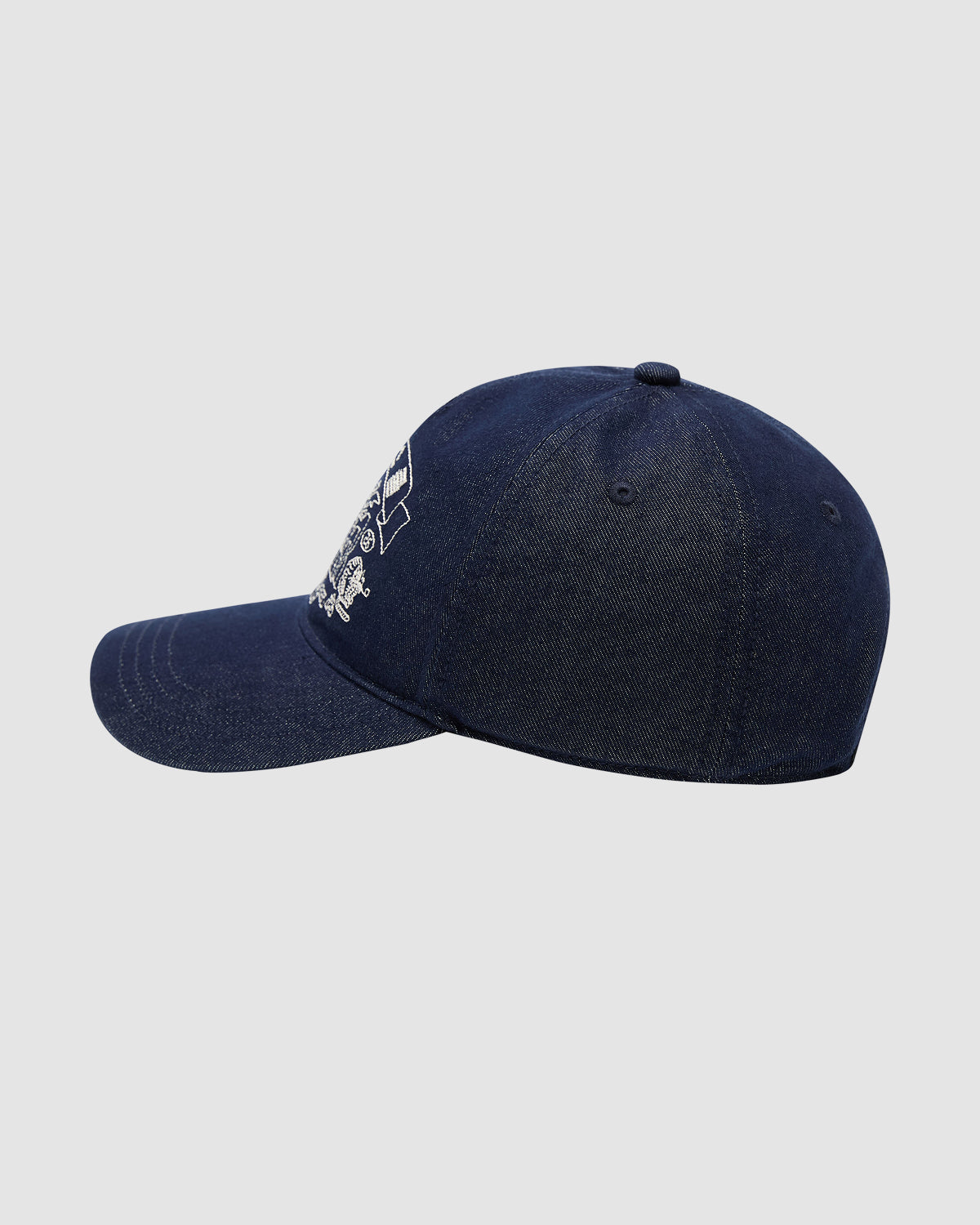 Side view of Sundae School’s INDIGO DENIM TIGER CAP—a dark blue denim strapback with a curved brim and partial Korean folk-art embroidery on the front—displayed against a plain light gray background.