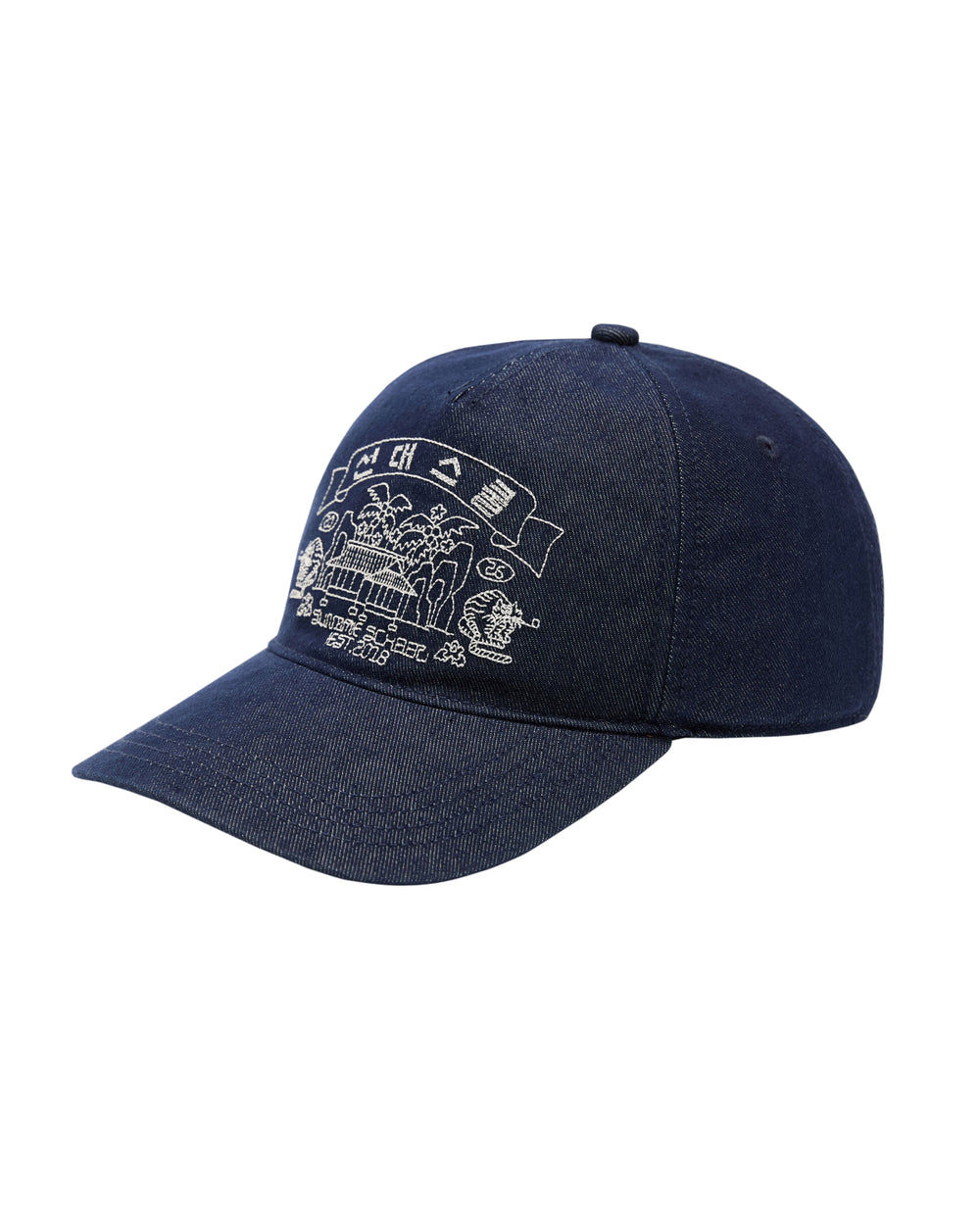 The TIGER DEN CAP by Sundae School is a dark blue denim strapback hat made from a premium cotton blend, featuring white Korean folk-art embroidery of a building, trees, flags, and small decorative elements on the front.